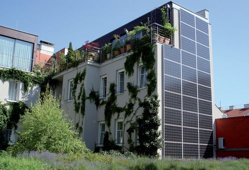 Building with solar panels and covered in plants