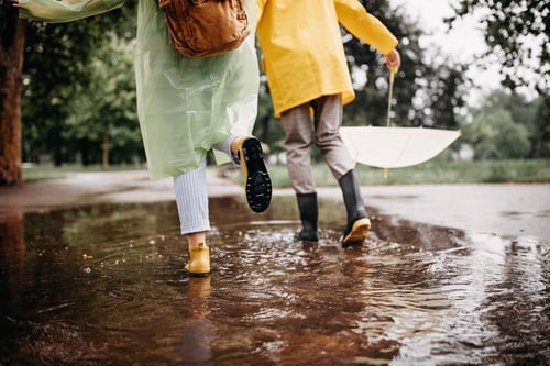 Regenponcho und Pfuetze