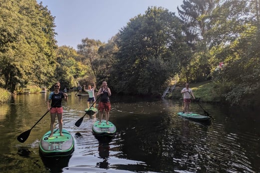 Team stand up paddling on a lake