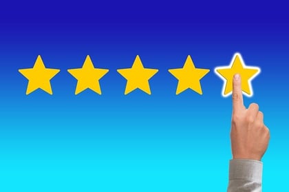 Finger choosing a digital 5-star rating for a hotel 