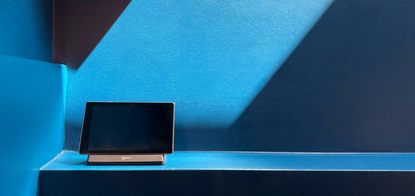 SuitePad in front of a blue wall