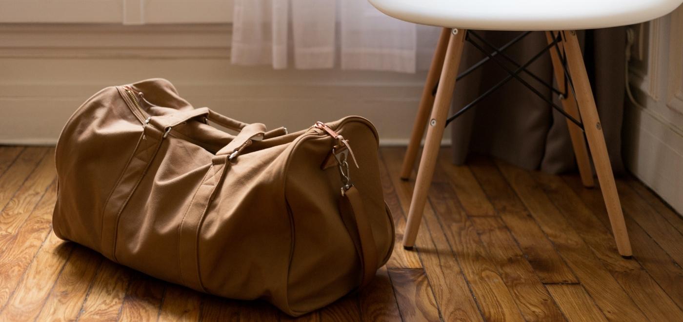 Eine Reisetasche steht auf dem Boden neben einem Stuhl