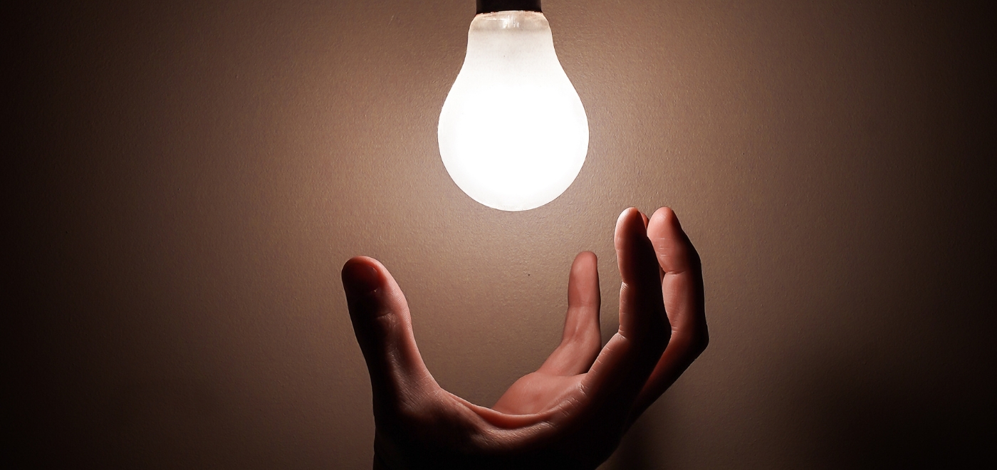 An image of a lightbulb and a hand