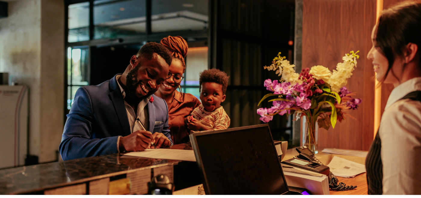 front desk manager welcoming a family at a hotel